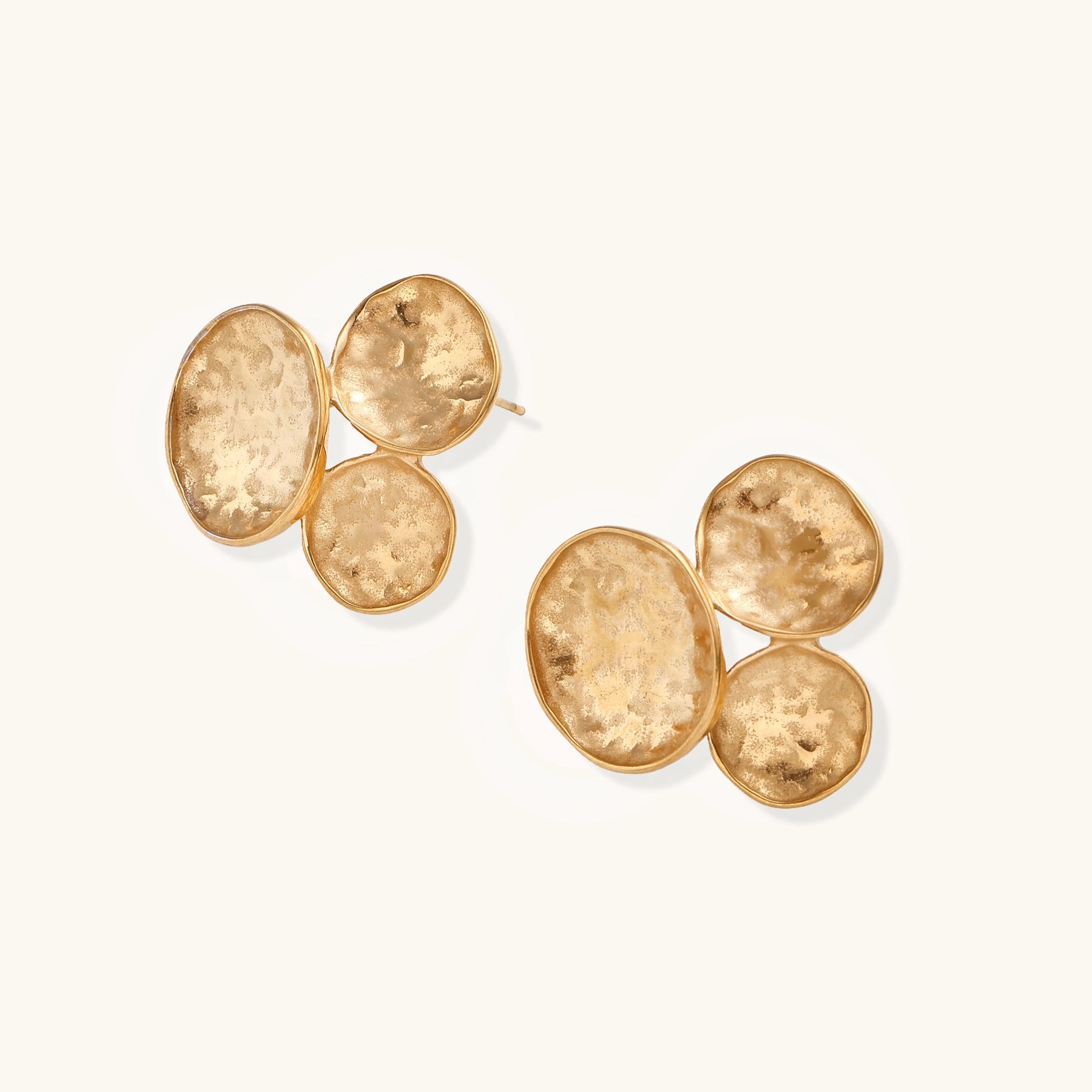 Sculptural gold-plated stainless steel earrings with three hammered oval shapes arranged in artistic cluster formation